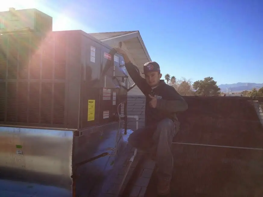 HVAC technician performing AC Tune-Up on a rooftop unit in Northfield